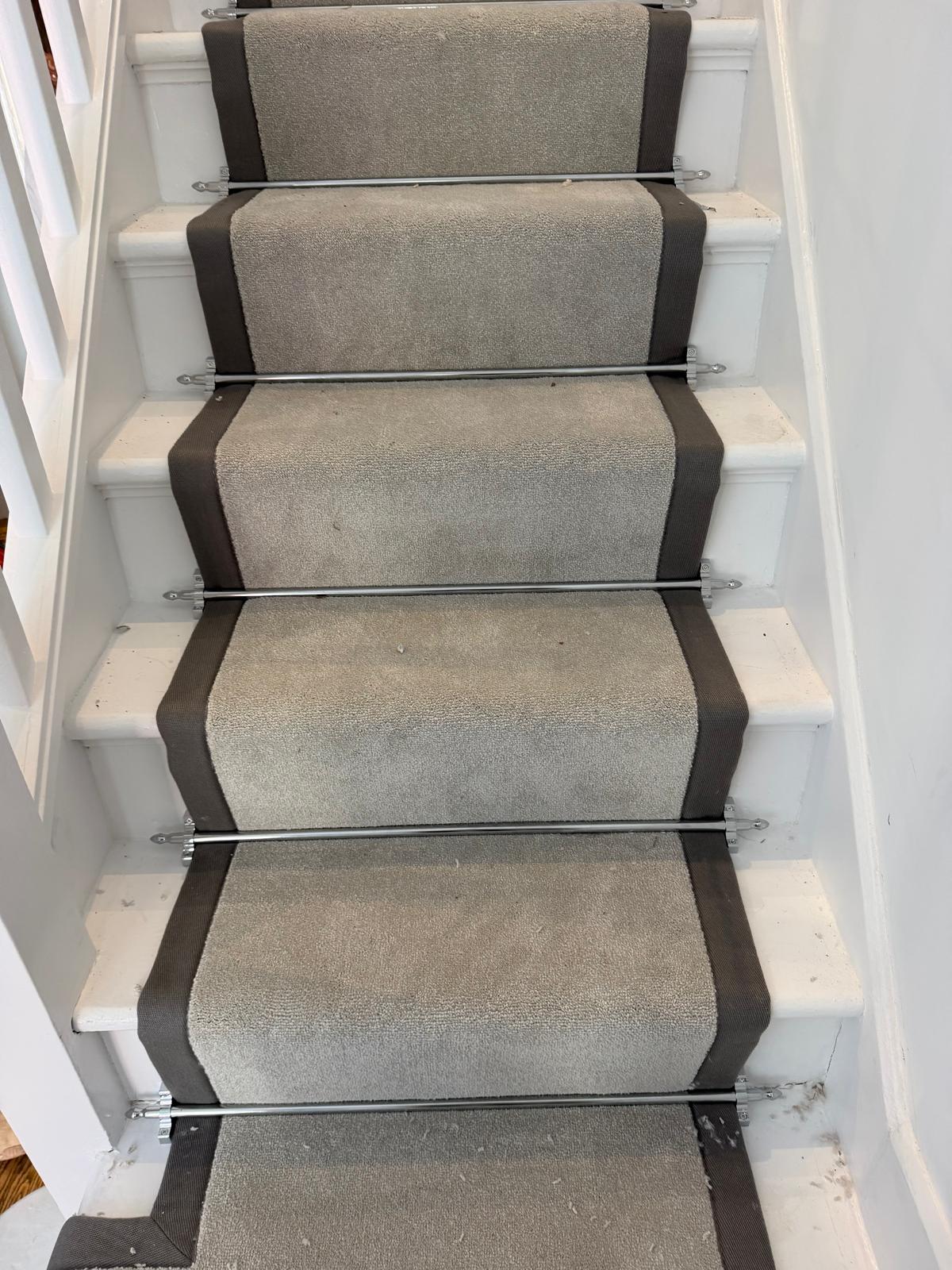 Grey Abingdon carpet stair runner with midnight blue taping and metallic stair rods in a renovated Surbiton home.