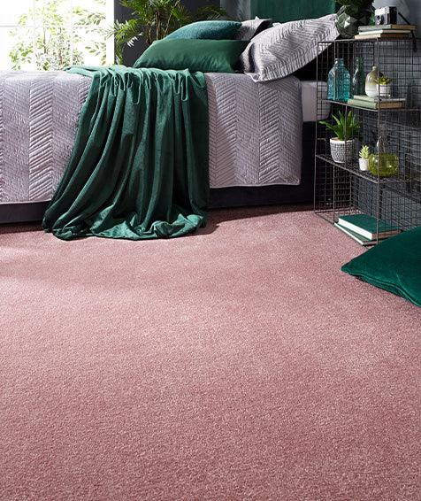 Soft pink carpet flooring in a cozy bedroom with green accents and modern decor
